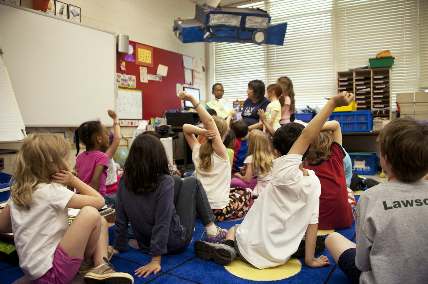 Kids raising hands during a group activity